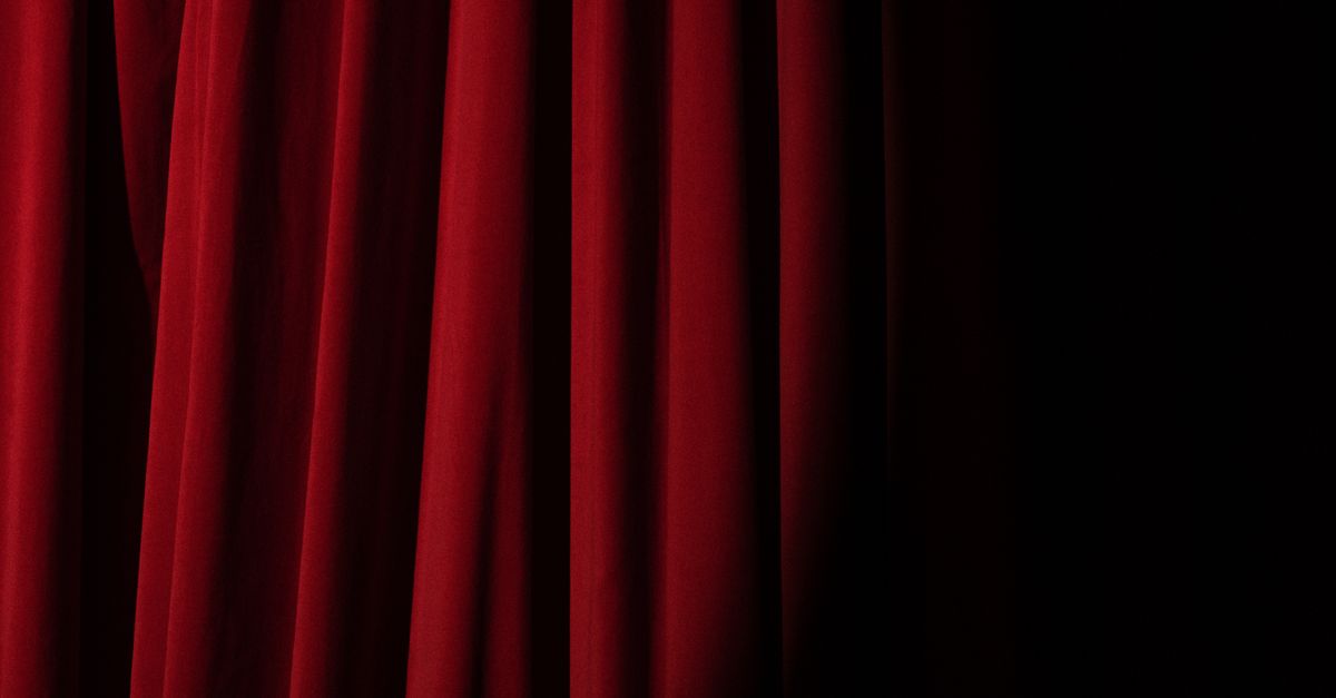 Elegant red velvet curtain with dramatic lighting perfect for theater themes.